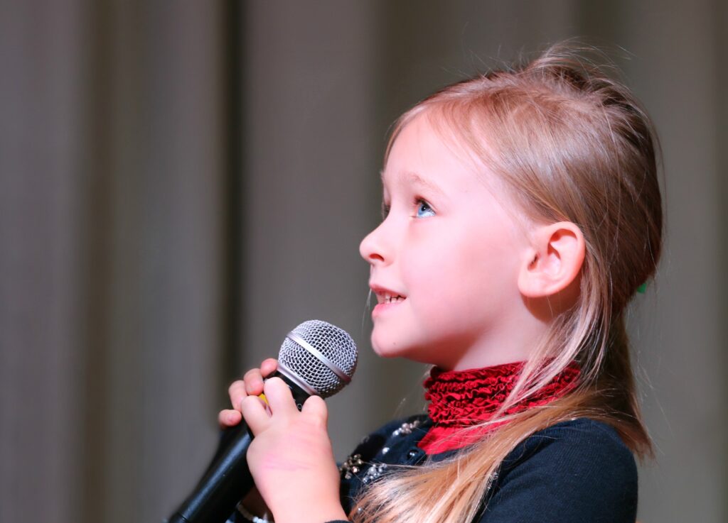 child speaking into microphone